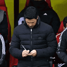 Mikel Arteta taking notes on the touchline